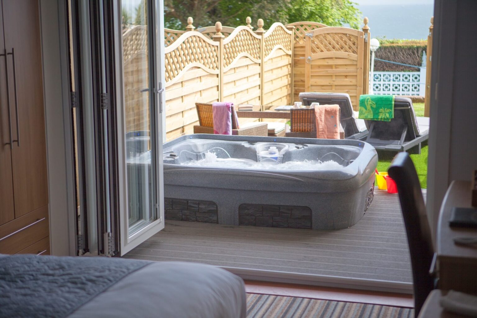 Looking from the Superior Garden Room bed out to its private sunken hot tub