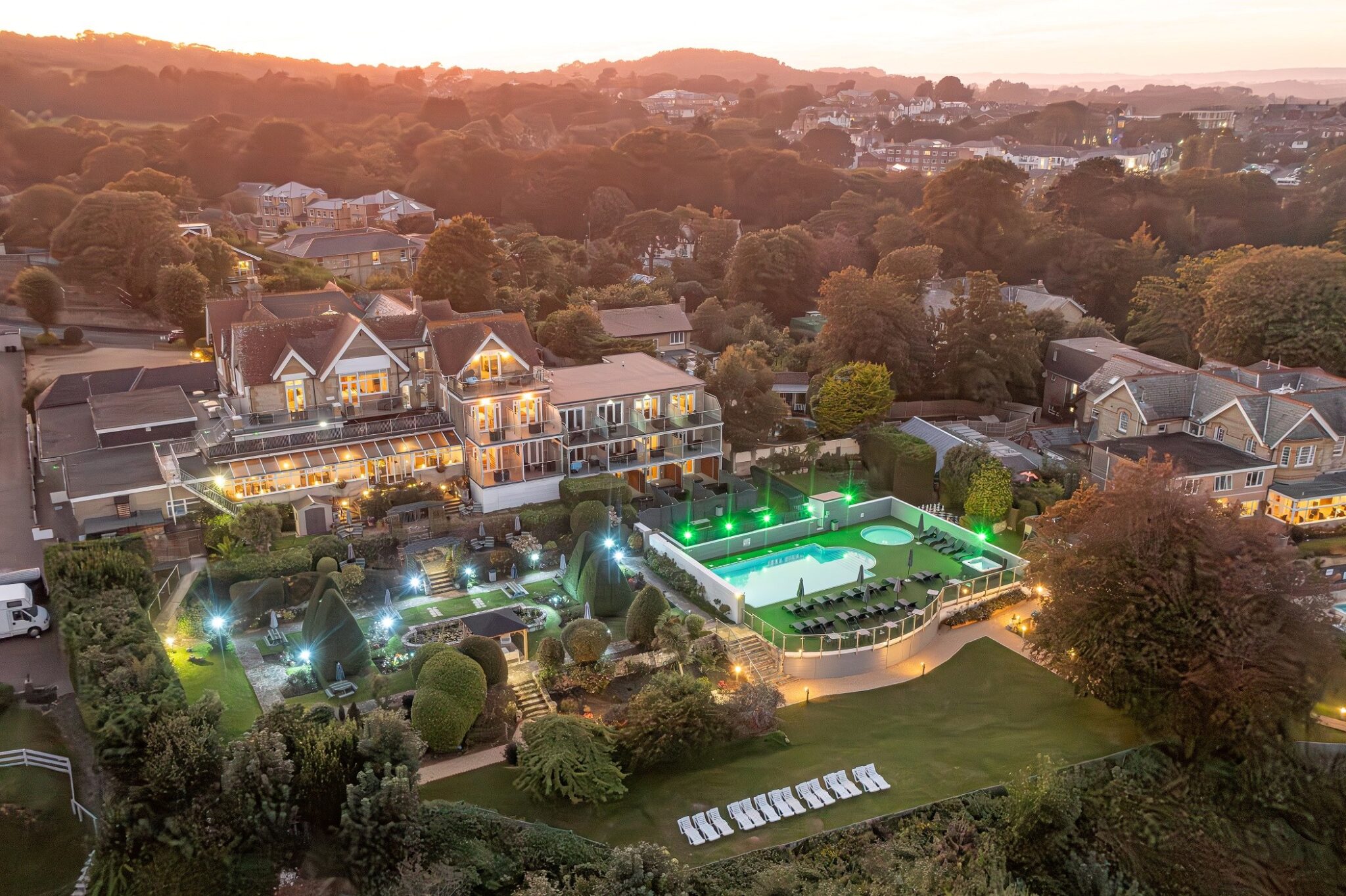 Luccombe Hall and its gardens lit up at dusk on the clifftop above Shanklin